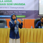 Staf Tata Usaha FAI UNUSIDA Bagikan Praktik Tata Kelola Arsip Modern, Perkuat Kompetensi Tenaga Kependidikan 7 Nuzula Firdausi, S.Pd., Staf Tata Usaha Fakultas Agama Islam (FAI) UNUSIDA, dalam kegiatan Sosialisasi Penguatan Kedisiplinan, Tata Kelola Arsip, dan Apresiasi SDM UNUSIDA di Hall Lantai 5 Gedung A, Kampus UNUSIDA, Selasa (13/10/2026). (Foto: Humas UNUSIDA)